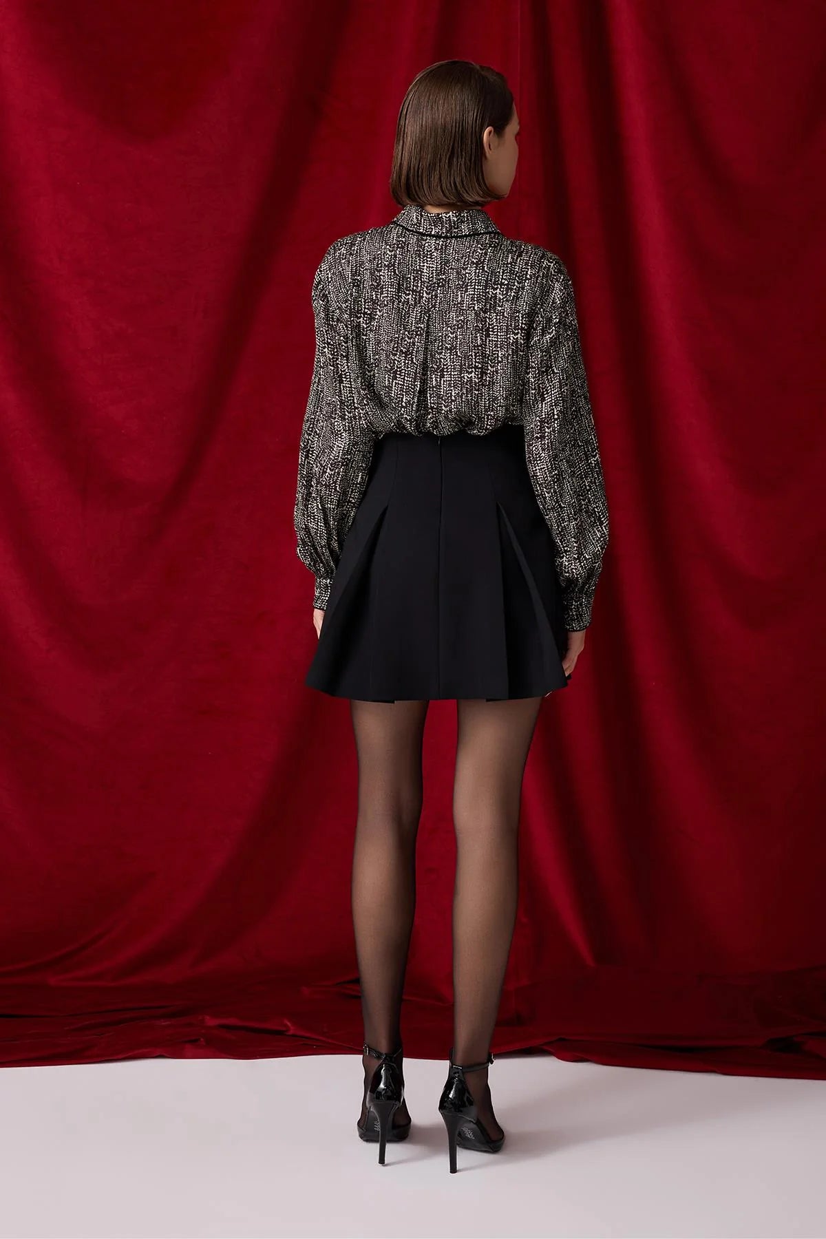 Pleated black skirt with gold buttons